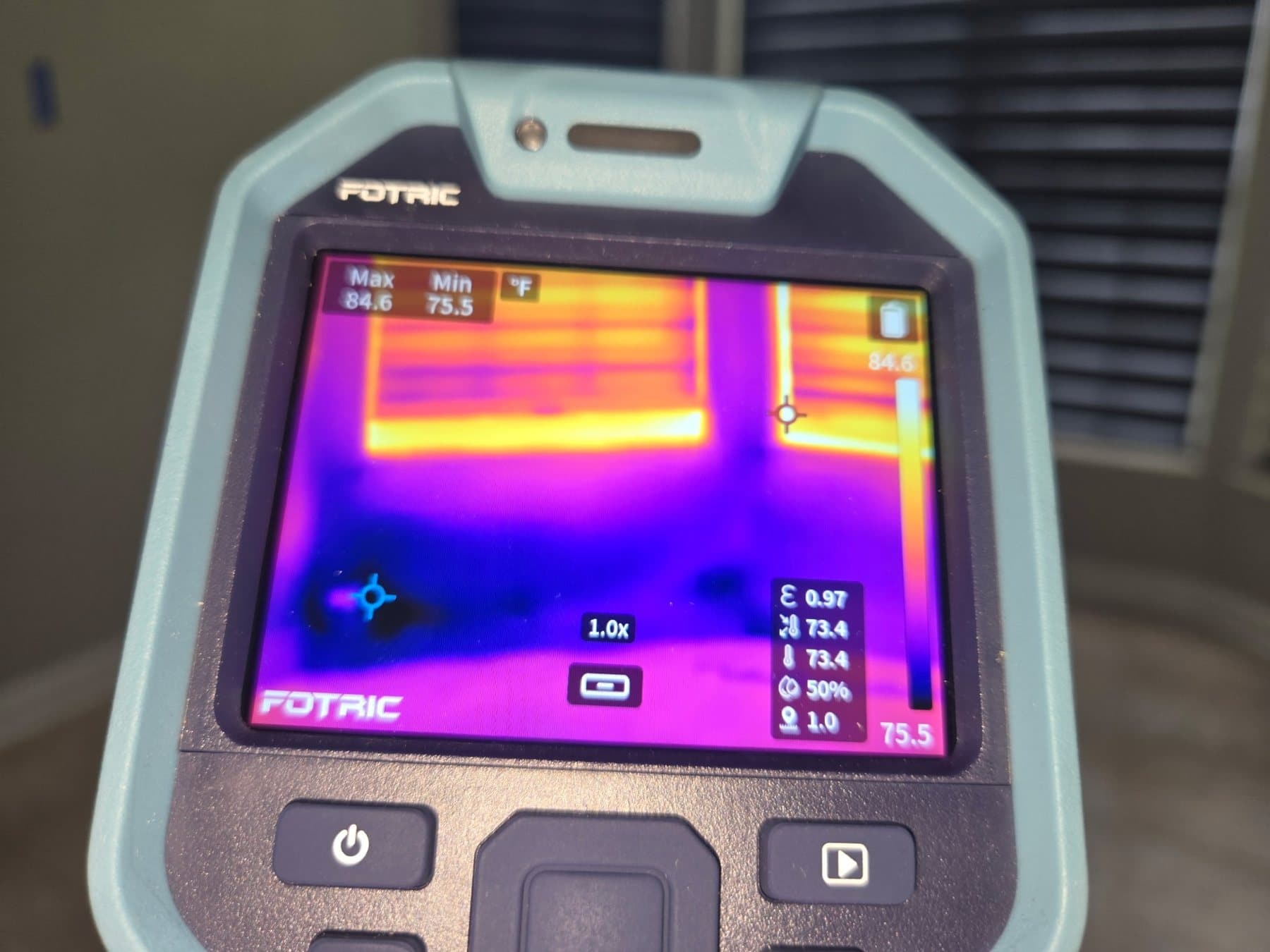 Thermal camera screen showing warm window shutters above a cooler band of wall